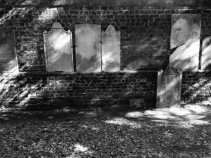 Broken headstones along back wall of Colonial